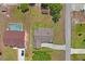 An aerial view of a property featuring a house, pool, storage shed, and surrounding landscape at 7270 Nightwalker Rd, Weeki Wachee, FL 34613