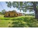 Expansive backyard featuring lush green lawn and mature trees providing shade and privacy at 7270 Nightwalker Rd, Weeki Wachee, FL 34613
