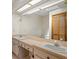 Bathroom with double sinks, a large mirror, and a separate toilet area for added privacy at 7270 Nightwalker Rd, Weeki Wachee, FL 34613