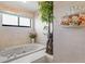 Relaxing bathroom featuring a large tub, floral accents, and natural light from the window at 7270 Nightwalker Rd, Weeki Wachee, FL 34613