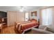Well-lit bedroom with a ceiling fan, wood floors, striped bedding, and a cozy chair at 7270 Nightwalker Rd, Weeki Wachee, FL 34613