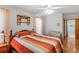 Comfortable bedroom featuring a ceiling fan, orange and white bedding, and ample natural light at 7270 Nightwalker Rd, Weeki Wachee, FL 34613