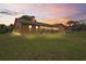 A view of the house's rear exterior featuring a spacious lawn and sunroom at 7270 Nightwalker Rd, Weeki Wachee, FL 34613