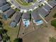 An aerial view of a backyard with an in-ground pool, patio, and partially grassed yard surrounded by a white fence at 733 Old Windsor Way, Spring Hill, FL 34609
