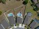 An aerial view of a backyard with an in-ground pool, patio, and partially grassed yard surrounded by a white fence at 733 Old Windsor Way, Spring Hill, FL 34609