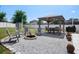 A beautiful backyard has a fire pit, covered dining, and manicured landscaping at 733 Old Windsor Way, Spring Hill, FL 34609