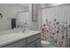 Bright bathroom with stylish vanity, shower curtain with flower motifs, and a clean, contemporary design at 733 Old Windsor Way, Spring Hill, FL 34609