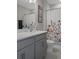 Bright bathroom with stylish vanity, shower curtain with flower motifs, and a clean, contemporary design at 733 Old Windsor Way, Spring Hill, FL 34609
