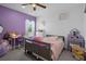 Bright bedroom with a desk, bed and lilac accents, creating a cozy and inviting atmosphere for children at 733 Old Windsor Way, Spring Hill, FL 34609
