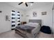 Well-lit bedroom featuring a cozy bed, ceiling fan, baseball decor, and a window with blue striped curtains at 733 Old Windsor Way, Spring Hill, FL 34609