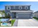 Charming two-story home featuring a private pool, landscaped front yard, and a gray two-car garage at 733 Old Windsor Way, Spring Hill, FL 34609