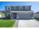 Charming two-story home with a landscaped front yard, complemented by a gray two-car garage at 733 Old Windsor Way, Spring Hill, FL 34609