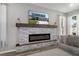 Stone fireplace with mantle and electric fireplace is the focal point of this living room at 733 Old Windsor Way, Spring Hill, FL 34609