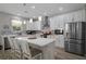 Modern kitchen featuring stainless steel appliances, white cabinets, a large island, and decorative pendant lights at 733 Old Windsor Way, Spring Hill, FL 34609
