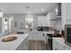 Contemporary kitchen with stainless steel appliances, white cabinetry, and a quartz island at 733 Old Windsor Way, Spring Hill, FL 34609