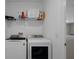 Modern laundry room with white washer and dryer and storage shelf for detergent and other laundry essentials at 733 Old Windsor Way, Spring Hill, FL 34609