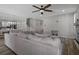 Open living space with an over sized sofa, ceiling fan, and stairs to the second floor at 733 Old Windsor Way, Spring Hill, FL 34609