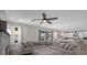 Open living space with an over sized sofa, ceiling fan, and open to the kitchen and dining area at 733 Old Windsor Way, Spring Hill, FL 34609