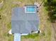 Aerial view of home showcasing screened pool, gray roof, driveway, and backyard at 7538 Landmark Dr, Spring Hill, FL 34606