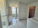 A luxurious bathroom featuring tile floors, a soaking tub, and a separate walk-in closet at 7538 Landmark Dr, Spring Hill, FL 34606