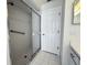 Bathroom features a shower with glass doors, grab bar, and neutral tile at 7538 Landmark Dr, Spring Hill, FL 34606