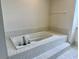Relaxing bathroom with a deep soaking tub and tiled accents for a spa-like experience at 7538 Landmark Dr, Spring Hill, FL 34606