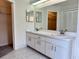 Bright bathroom with a double sink vanity, white cabinets, and a large mirror at 7538 Landmark Dr, Spring Hill, FL 34606
