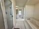 Bathroom with a shower, soaking tub, and tile flooring, providing an oasis for relaxation at 7538 Landmark Dr, Spring Hill, FL 34606