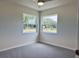 Bedroom featuring two windows providing ample natural light and a view of the yard at 7538 Landmark Dr, Spring Hill, FL 34606