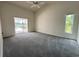 Airy bedroom with a ceiling fan, sliding glass doors to the pool area, and large windows at 7538 Landmark Dr, Spring Hill, FL 34606