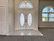 Inviting foyer features a tiled entryway with double doors, arched window, and a closet at 7538 Landmark Dr, Spring Hill, FL 34606