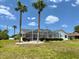 Exterior view of the home with a screened pool area and palm trees at 7538 Landmark Dr, Spring Hill, FL 34606