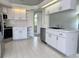 Well-maintained kitchen with tile floors, white cabinetry, stainless dishwasher and sink at 7538 Landmark Dr, Spring Hill, FL 34606