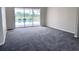 Bright living room featuring neutral carpet and sliding doors leading to a screened pool area at 7538 Landmark Dr, Spring Hill, FL 34606