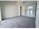 Well-lit living room featuring carpet, a ceiling fan, and a view of the front entrance at 7538 Landmark Dr, Spring Hill, FL 34606