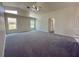 Bright living room with vaulted ceiling, carpet flooring, and large windows at 7538 Landmark Dr, Spring Hill, FL 34606