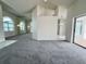 Open-concept living room with neutral carpet, white walls, and access to kitchen and pool area at 7538 Landmark Dr, Spring Hill, FL 34606