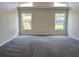 Spacious living room boasts vaulted ceilings, plush carpeting, and natural light from the large windows at 7538 Landmark Dr, Spring Hill, FL 34606