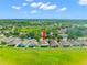 Aerial view showing the house, well-manicured lawn, and white picket fence with backyard patio at 779 Nodding Shade Dr, Brooksville, FL 34604