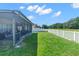 Backyard featuring a screened-in patio and a well-maintained lawn, creating a private oasis at 779 Nodding Shade Dr, Brooksville, FL 34604