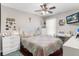 Cozy bedroom boasts a ceiling fan, a window, a TV, and a comfortable bed with a colorful patchwork quilt at 779 Nodding Shade Dr, Brooksville, FL 34604