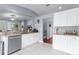 Bright kitchen features white cabinets, stainless steel dishwasher, and views to the outdoors through an open layout at 779 Nodding Shade Dr, Brooksville, FL 34604