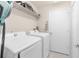 A functional laundry room with a washer, dryer, shelving, and a door for convenient access at 779 Nodding Shade Dr, Brooksville, FL 34604