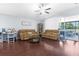 Spacious living room featuring hardwood floors, two leather sofas, and sliding doors to the lanai at 779 Nodding Shade Dr, Brooksville, FL 34604