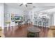 Bright living room with wood floors, a ceiling fan, bar stool seating, and a decorative entertainment center at 779 Nodding Shade Dr, Brooksville, FL 34604