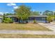 Charming single-story home with a well-maintained lawn, mature tree, and a gray exterior at 800 N Walton Ave, Tarpon Springs, FL 34689