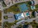 An aerial view shows the tennis court, pool and clubhouse at 8210 Aquila St # 218, Port Richey, FL 34668