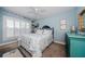 Cozy bedroom with blue walls, white shutters, and a decorative floral quilt at 8210 Aquila St # 218, Port Richey, FL 34668