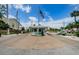 View of the gated entrance featuring an American flag, a guard house, and well-maintained landscaping at 8210 Aquila St # 218, Port Richey, FL 34668
