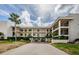 A condo building with balconies and a covered drive-through showcases tropical landscaping and a bright, sunny ambiance at 8210 Aquila St # 218, Port Richey, FL 34668